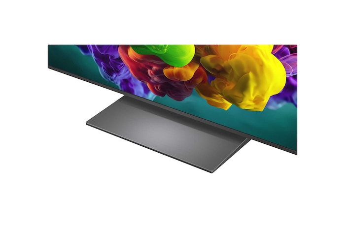 Een LG QNED evo AI QNED90 Mini LED ultragrote tv hangt aan de muur in een lichte woonkamer en toont een grootschalig sportevenement, met levendige kleuren en een geweldige beeldkwaliteit op een groot scherm, terwijl een gezin op verschillende banken zit en samen juicht.